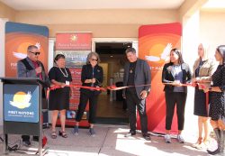First Nations leadership standing by the ribbon while Jackie Francke cuts the red ribbon. 